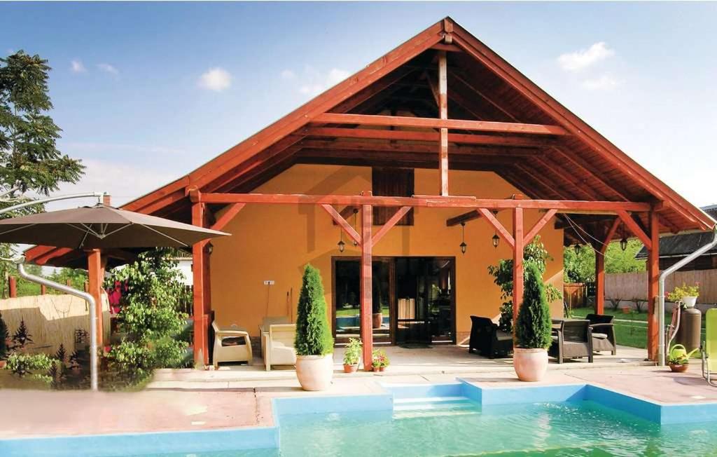 a house with a pool in front of it at CUKROS Villa in Cserkeszőlő