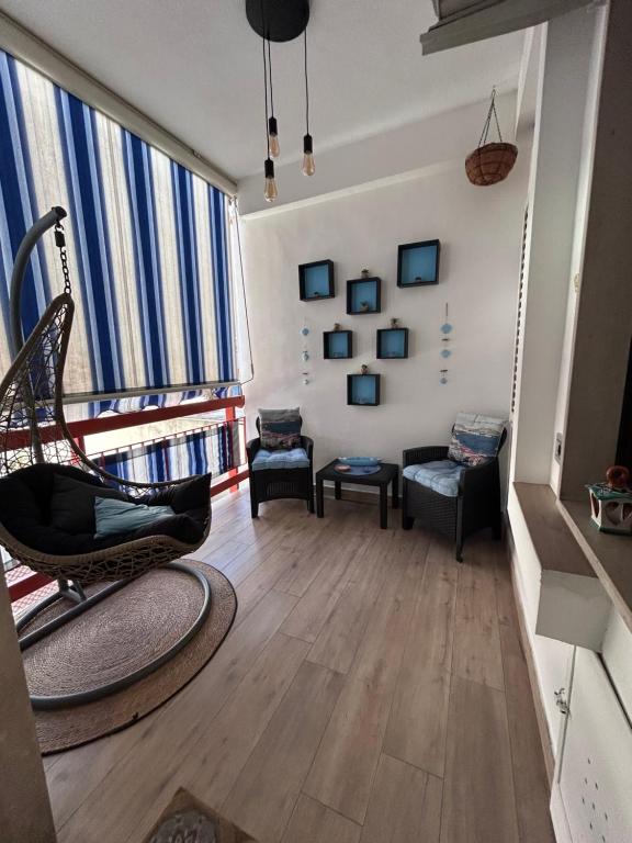 a living room with a chair and a large window at Armonica Apartment in Castellammare di Stabia