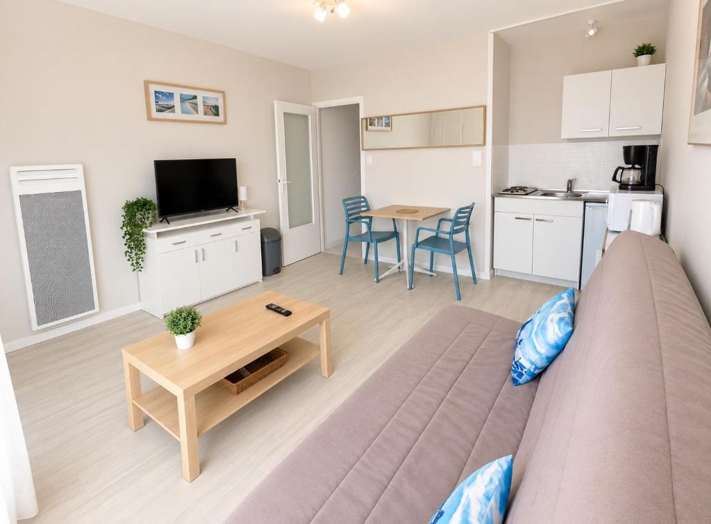 a living room with a couch and a table at Studio - Pleine Mer - 1 avenue des Pays de Monts - 1-1 in Saint-Jean-de-Monts