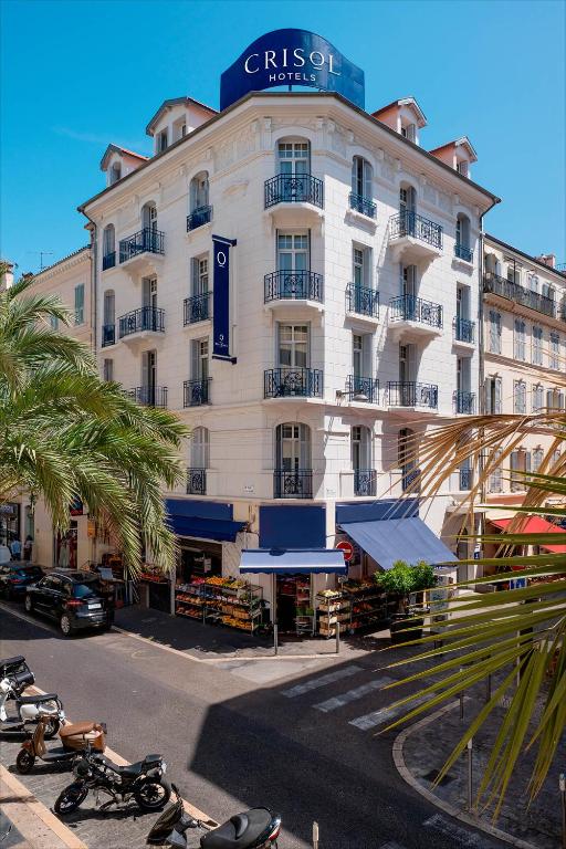 a large white building with motorcycles parked in front of it at Crisol Belle Epoque in Cannes