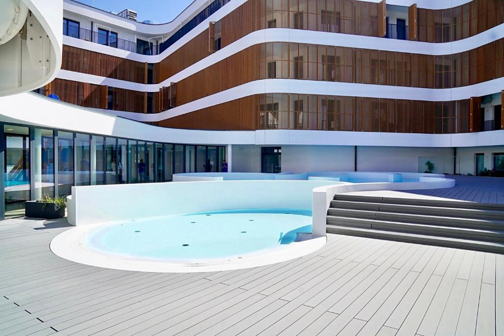 a building with a swimming pool in front of a building at Baltic Waves Resort by Baltic Home in Międzyzdroje