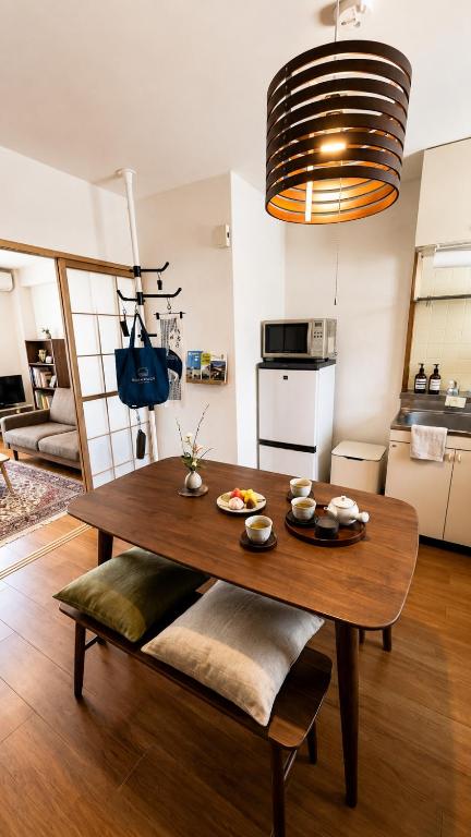 a living room with a wooden table and a kitchen at 牟礼ぐらし宿 in Takamatsu