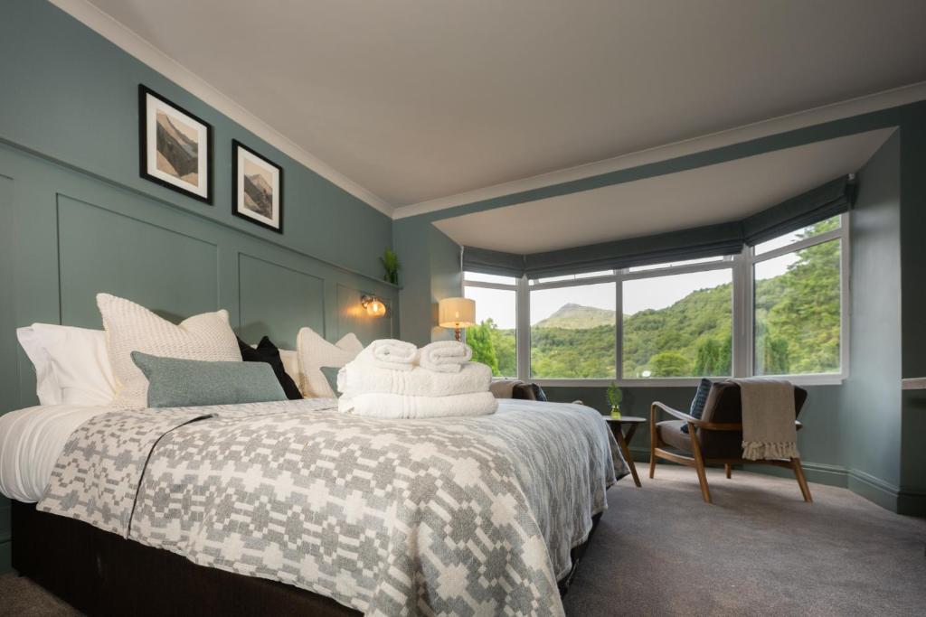 a bedroom with a bed and a large window at Tyn-y-Coed Inn in Betws-y-coed