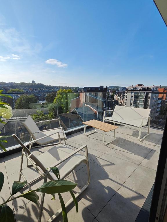 a balcony with chairs and a view of a city at Chez EdGare in Liège