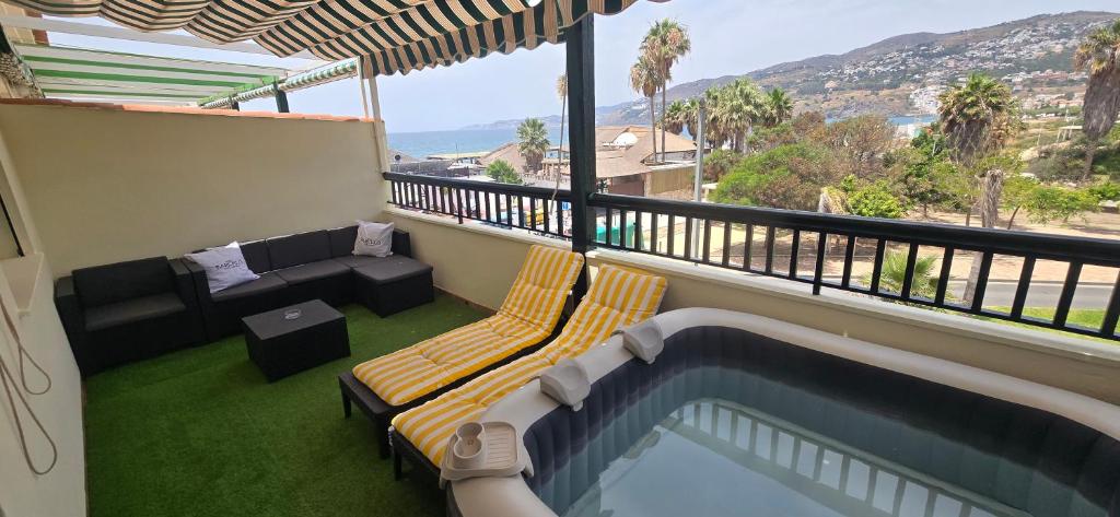 a balcony with a swimming pool and a couch at Terraza al mar in Salobreña