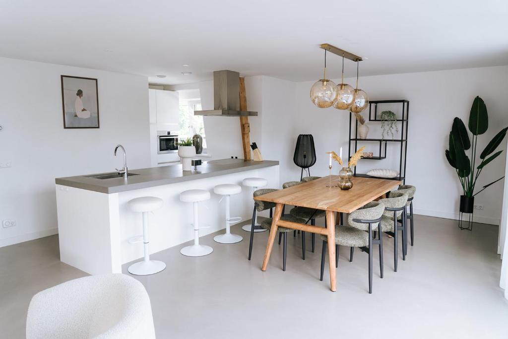 a kitchen and dining room with a wooden table and chairs at Oase in Bergen