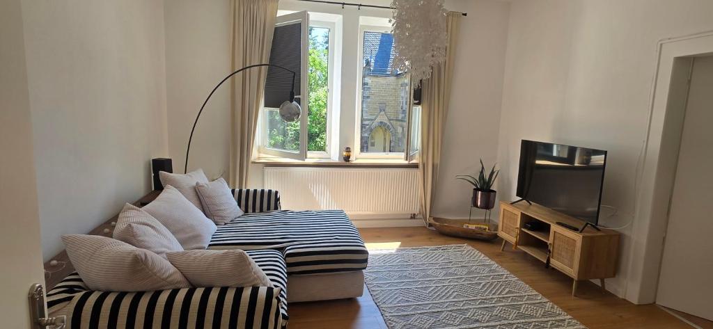 a living room with a couch and a tv at Cozy city appartement in Forchheim