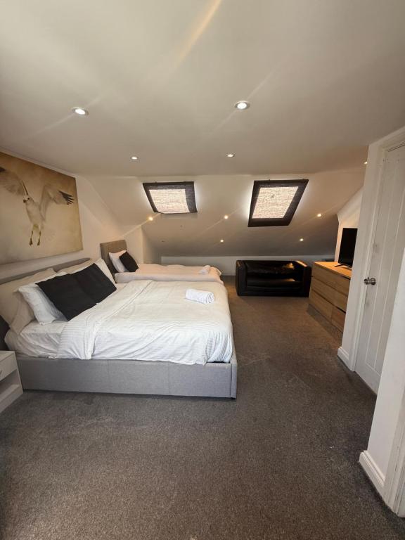 a bedroom with a large white bed and two windows at Bel Palace in Hackbridge