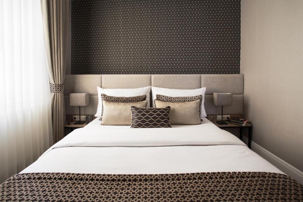 um quarto com uma grande cama branca com almofadas em Brill Budapest Apartments 3 em Budapeste