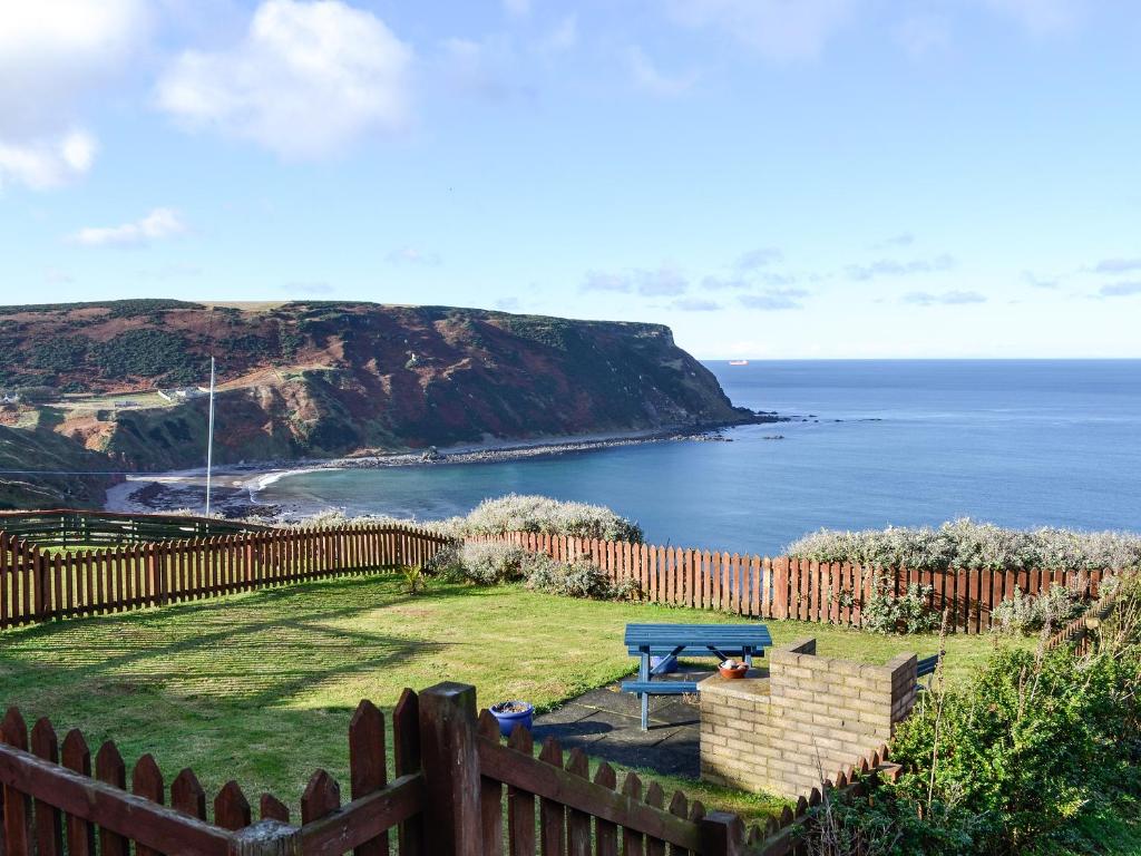 a backyard with a picnic table and the ocean at Ruach in Gardenstown