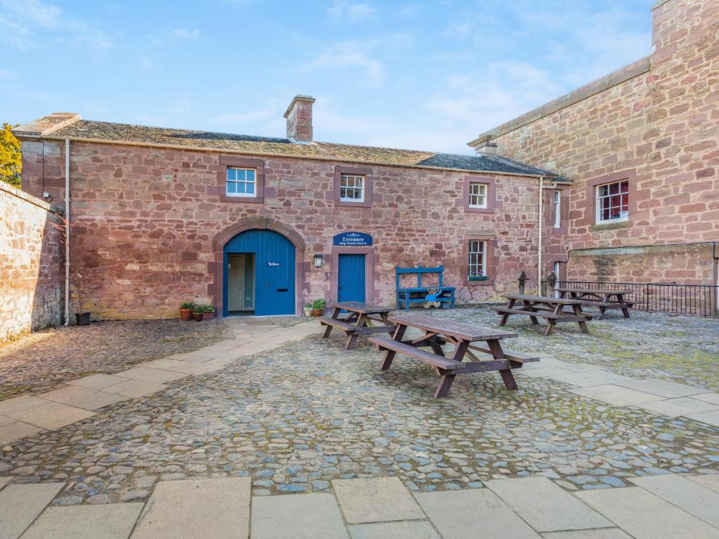 a group of benches in front of a brick building at The Garden Apartment - Uk48320 in Berwick-Upon-Tweed