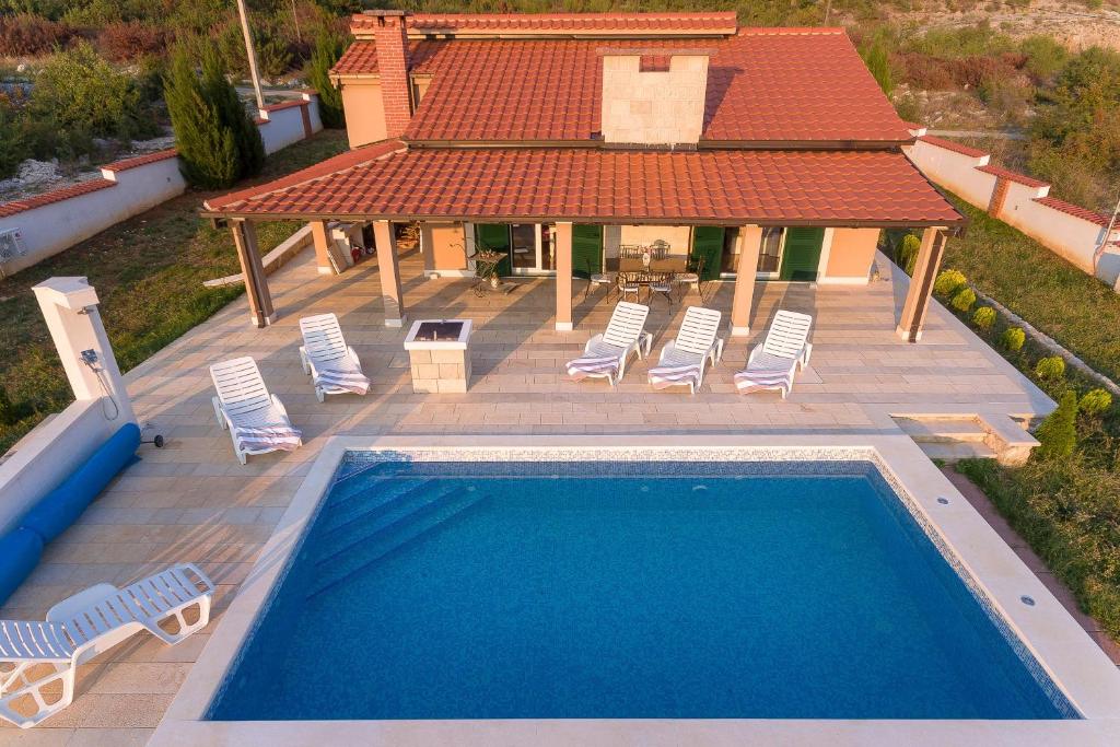 an overhead view of a swimming pool with chairs and a house at Villa Dea in Vučevica