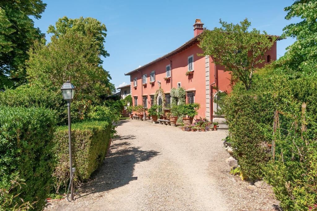 a road in front of a pink building at Villa Il Rossignolo con Piscina in Grassina