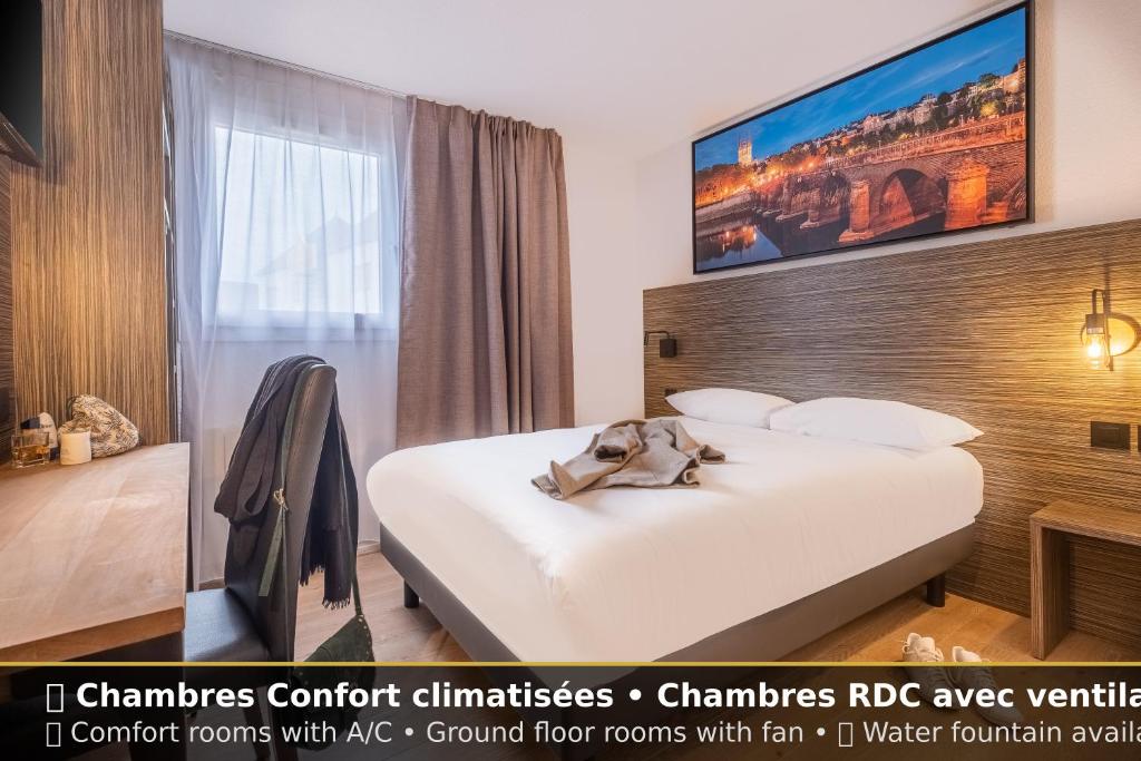 a hotel room with a large white bed in a room at Sure Hotel by Best Western Angers Sud in Les Ponts-de-Cé