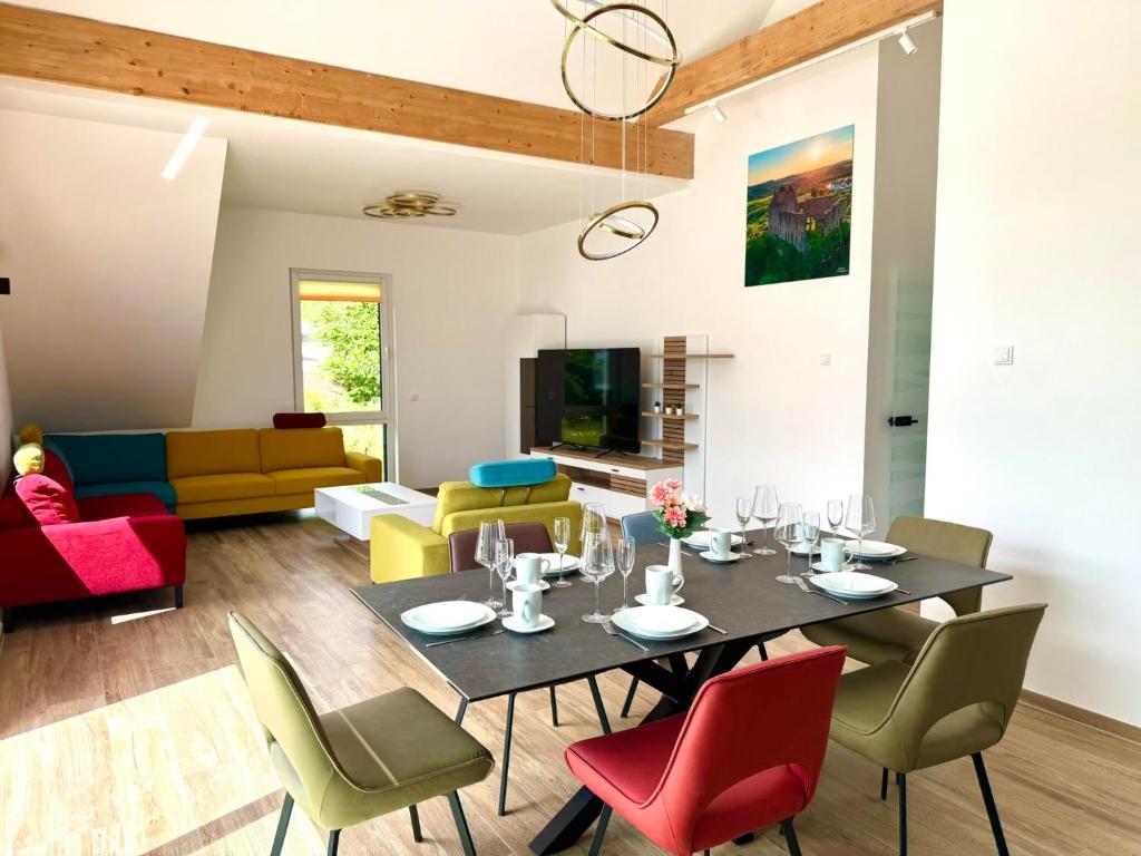 a dining room and living room with a table and chairs at Ferienwohnanlage Einzigartig in Saarburg