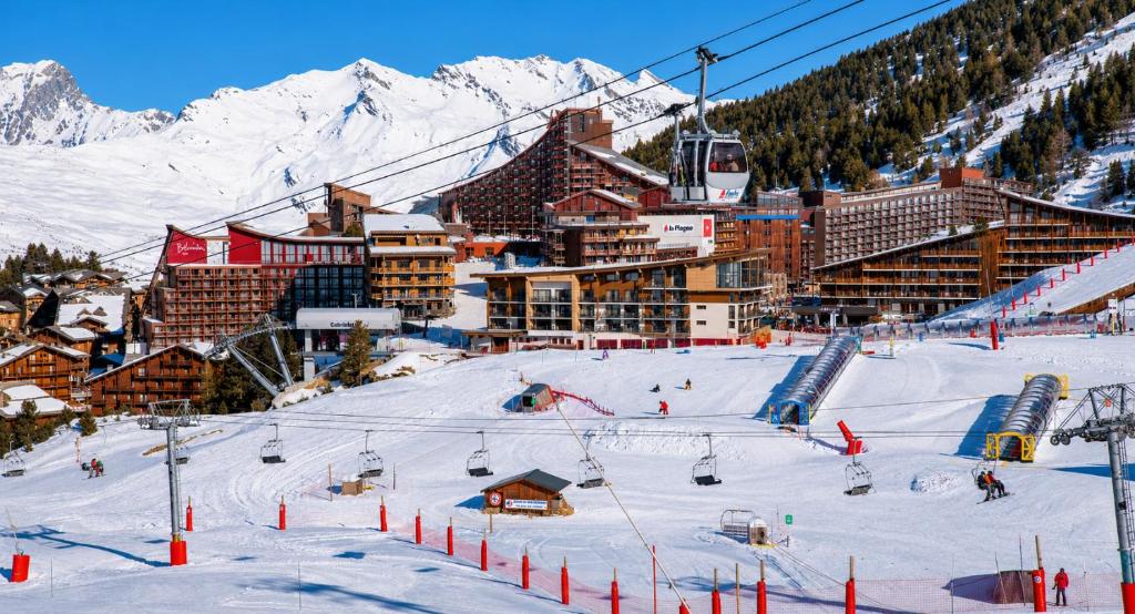 a ski resort with a ski lift in the snow at Résidence LE VARET - ARC 2000 - Ski-in Ski-out in Bourg-Saint-Maurice