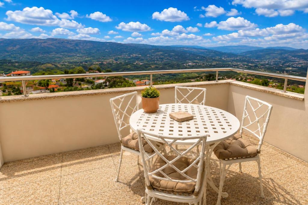 a table and chairs on a balcony with a view at Casa do Alto Vila Caiz in Amarante
