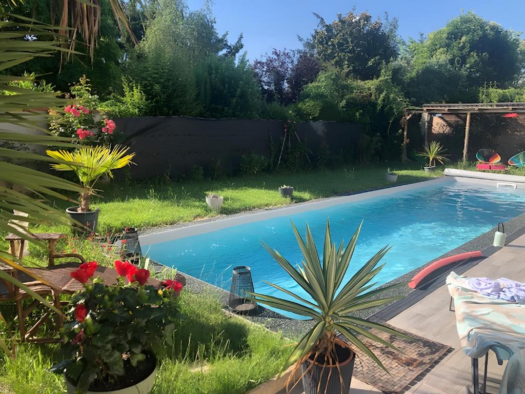 a swimming pool with plants in a yard at Villa Stella in Montauban