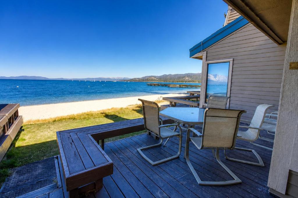 a deck with a table and chairs on the beach at Sky Lake Splendor condo in South Lake Tahoe
