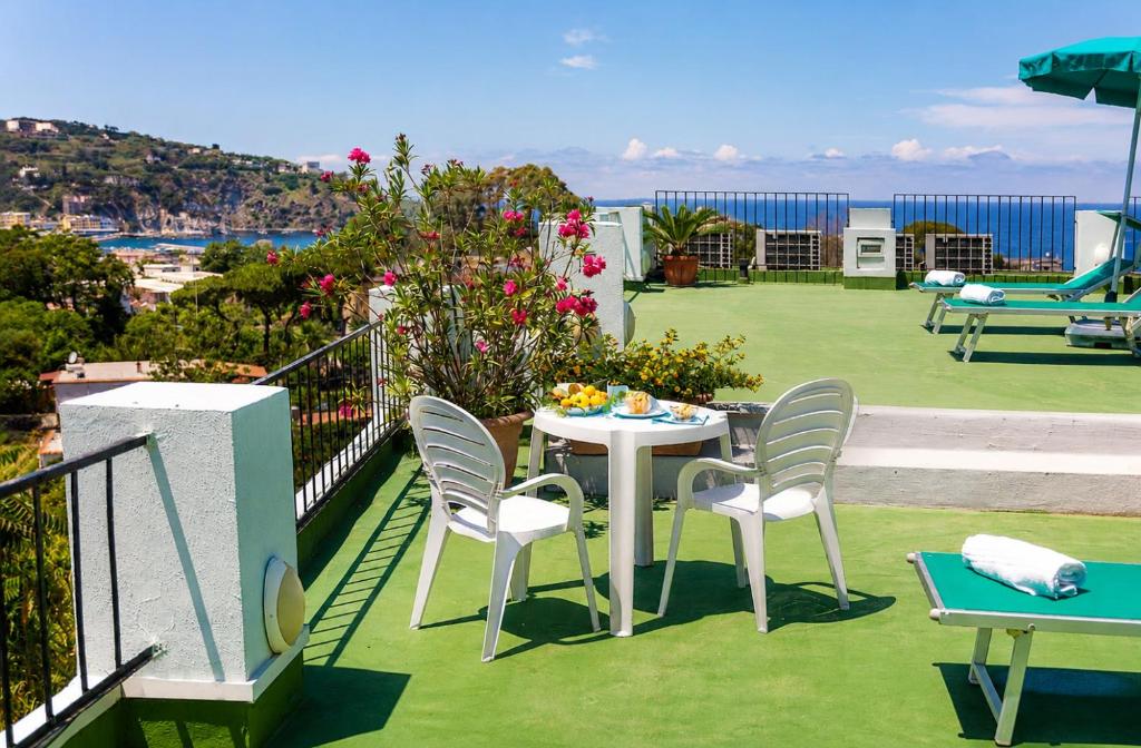 a table and chairs on a balcony with a view of the ocean at B&B Verde in Casamicciola Terme