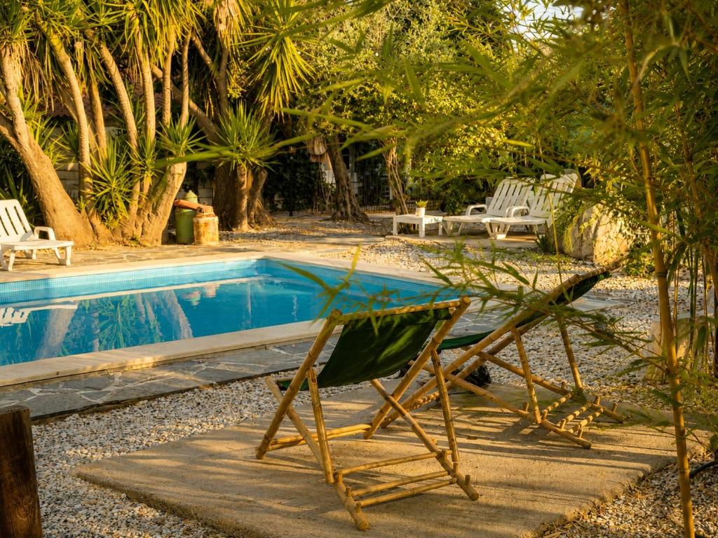 a chair sitting next to a swimming pool at Casa Rico Frade Garden in São Pedro do Corval
