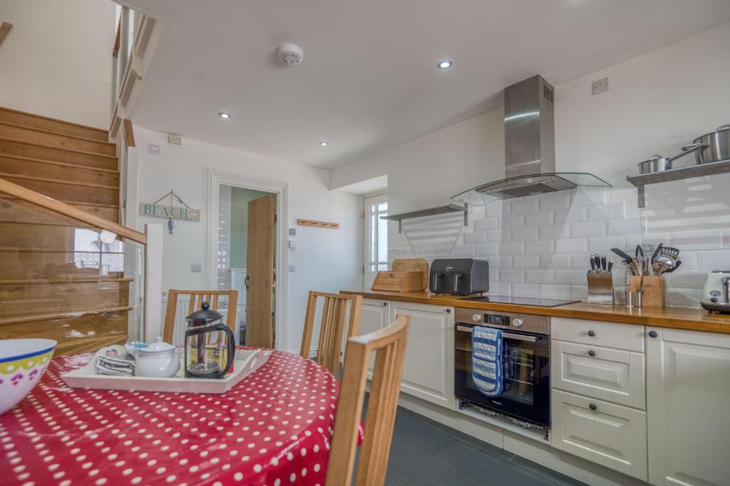 a kitchen with a table with a red and white table cloth at Hafod in Tenby