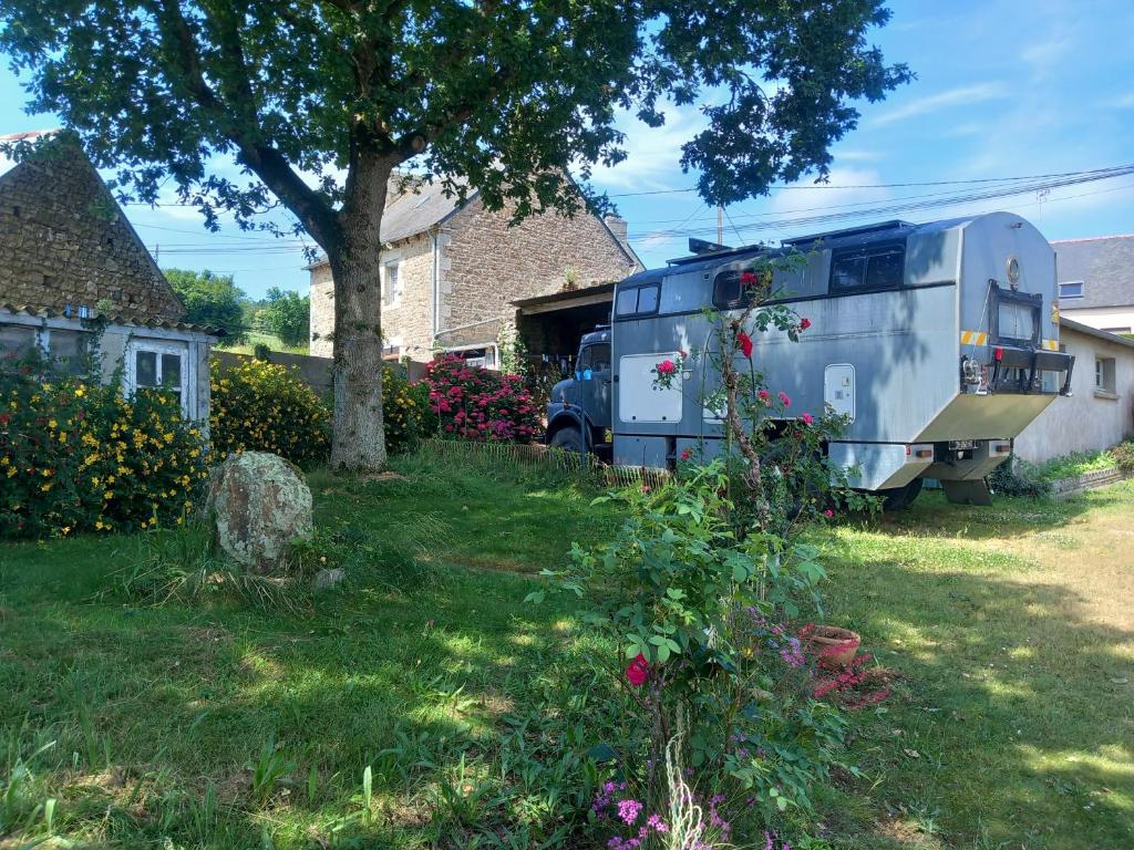 an rv parked in a yard next to a house at Campertruck Off-Grid in Hénon