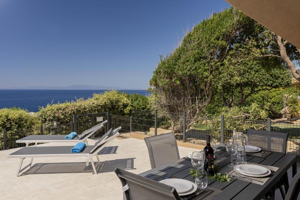 a table and chairs with a view of the ocean at Villetta Luce Marina in Costa Paradiso