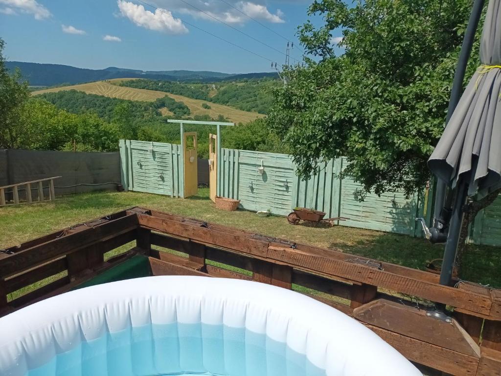 a view of a backyard with a pool and a fence at CHILLY WILLY Retro Caravan & Hot Tub in Jablonov nad Turnou