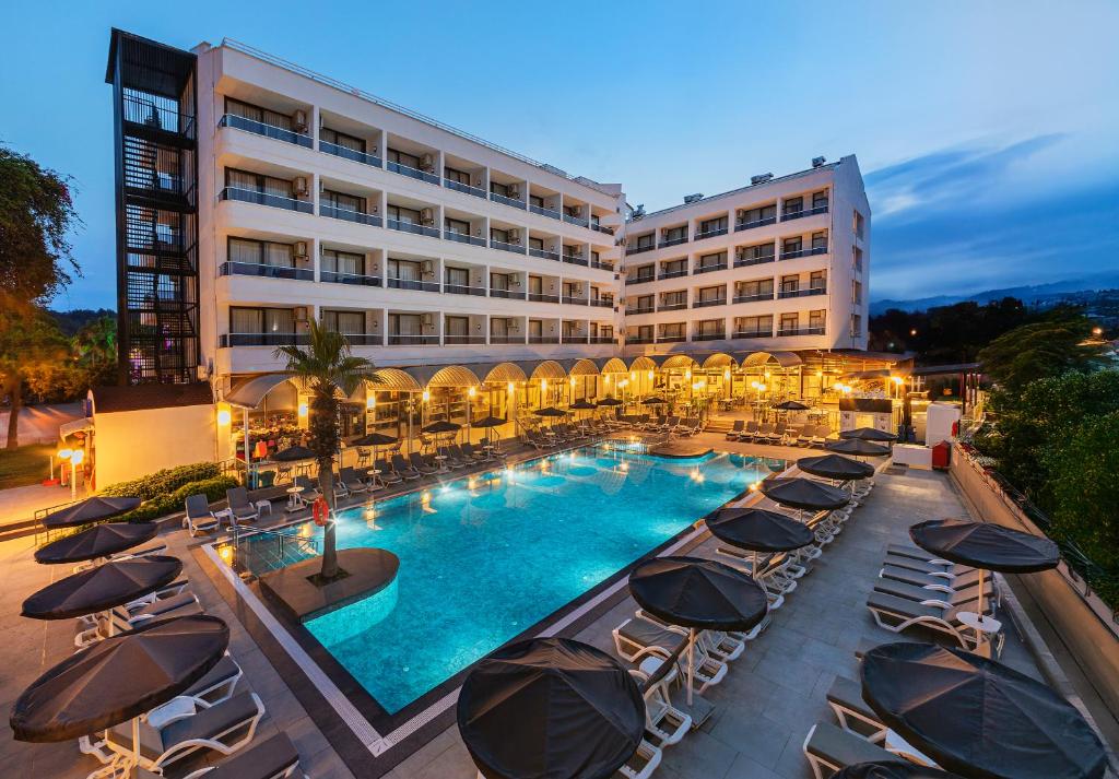 a hotel with a swimming pool with chairs and umbrellas at K Maris Hotel in Marmaris
