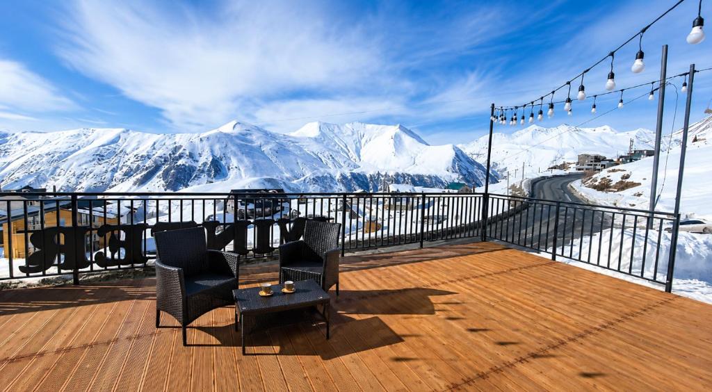 a balcony with a view of snow covered mountains at winter house GUDAURI in Gudauri