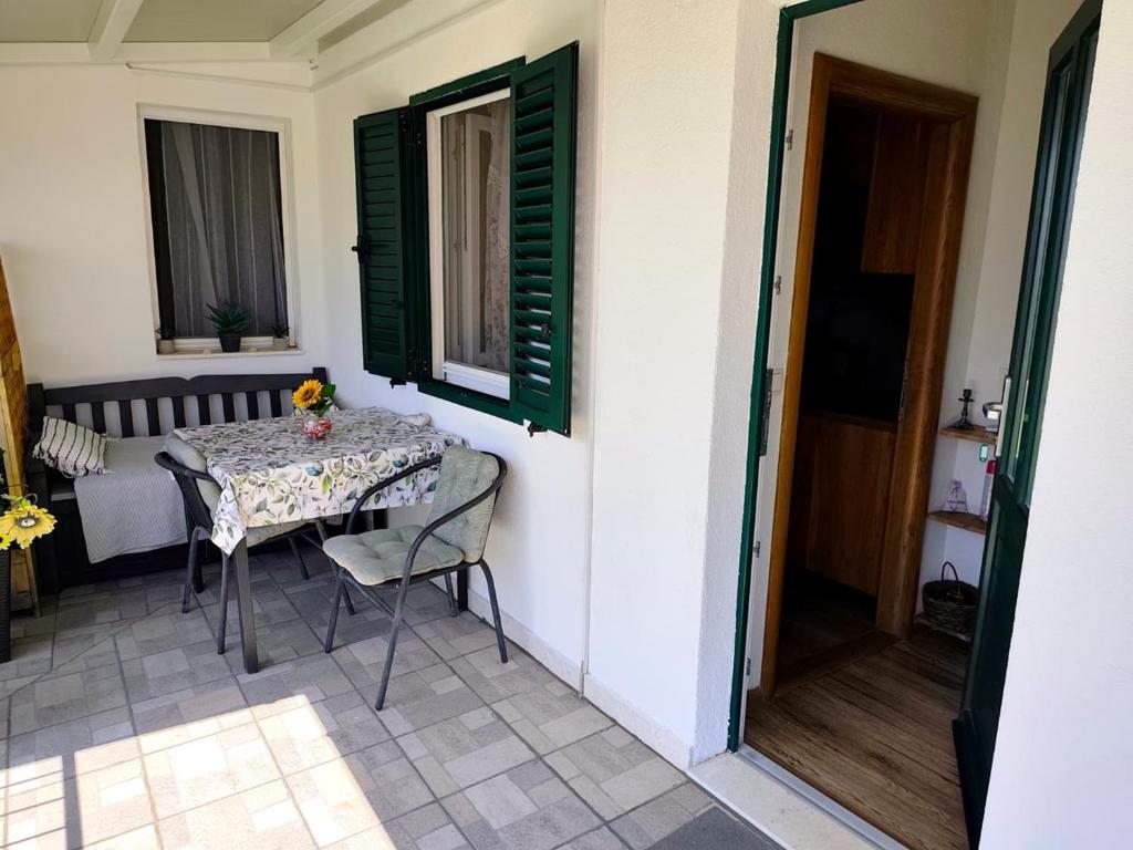 a table and chairs in a room with a window at Apartment Lore in Primošten
