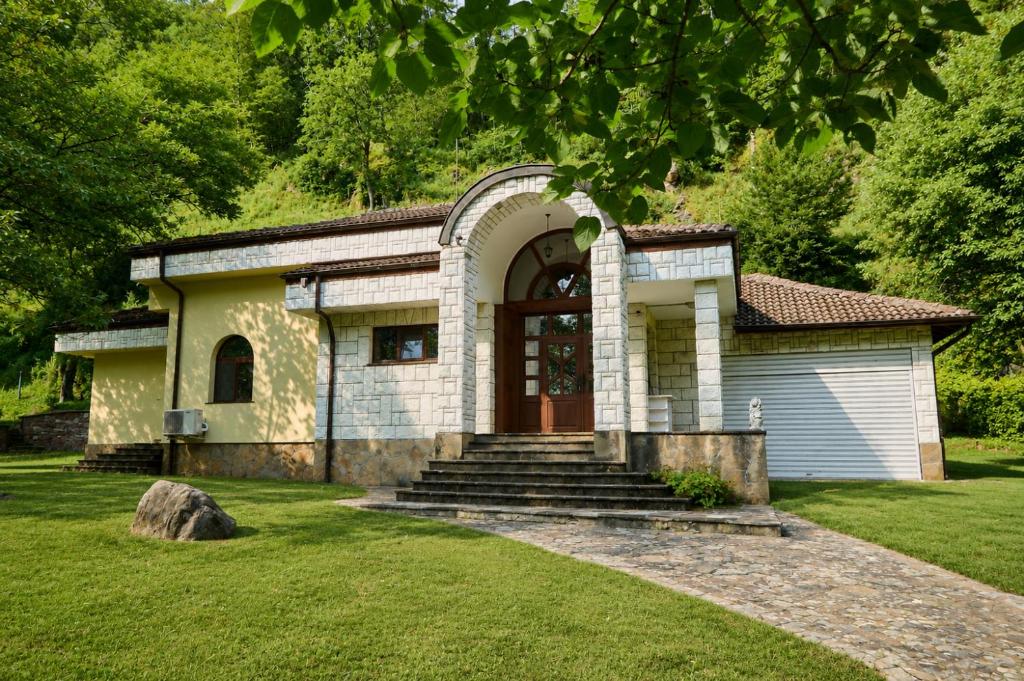a small house with a large door in a yard at Guest House Fedor in Ribarica