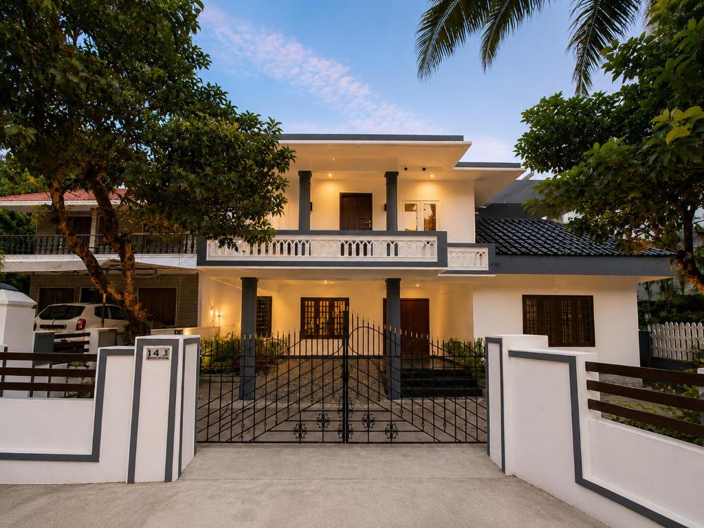 a white house with a fence in front of it at Chooravelil Villa, Adimali - Family Stay Near Munnar in Anniyartholu