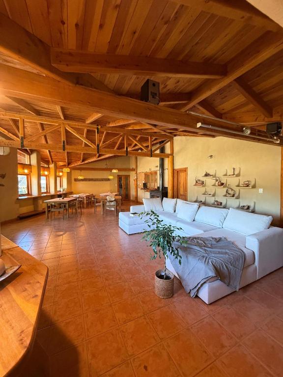 a large living room with white couches and a table at Posada La Tregua in El Bolsón