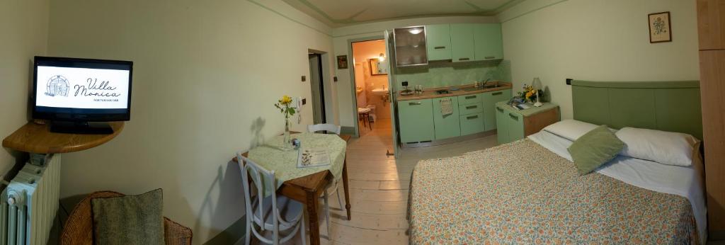 a living room with a tv and a kitchen at Villa Monica in Brentonico