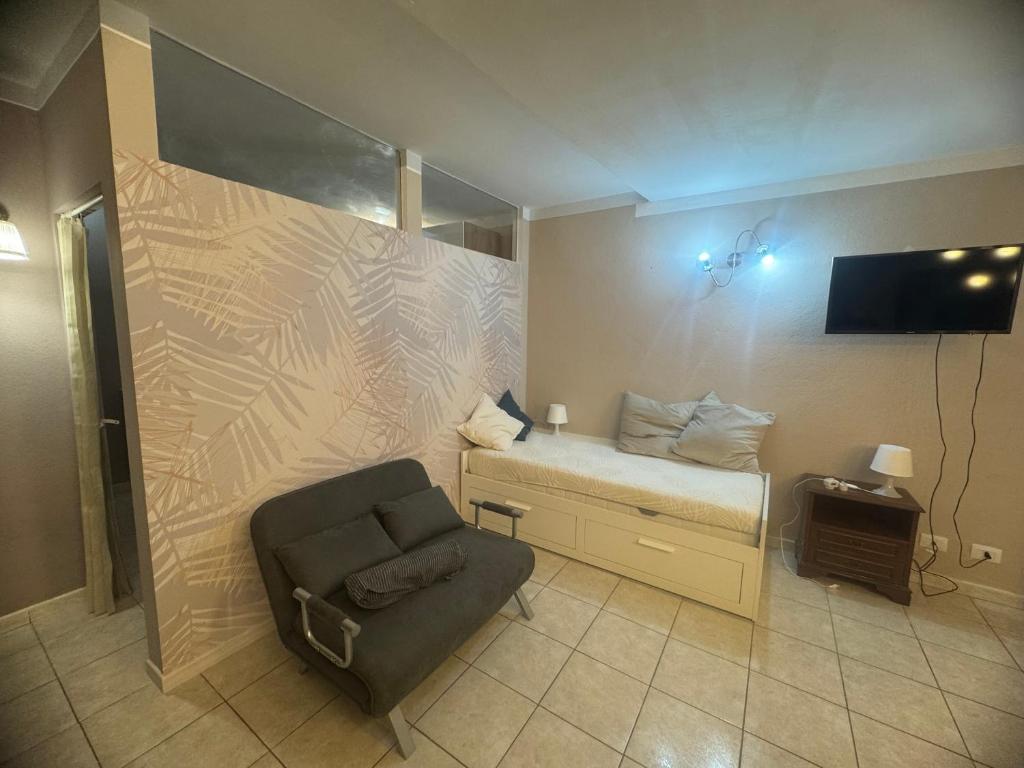 a room with a bed and a chair and a tv at La Casa di Maya a due passi da Sestriere in Grange Sises