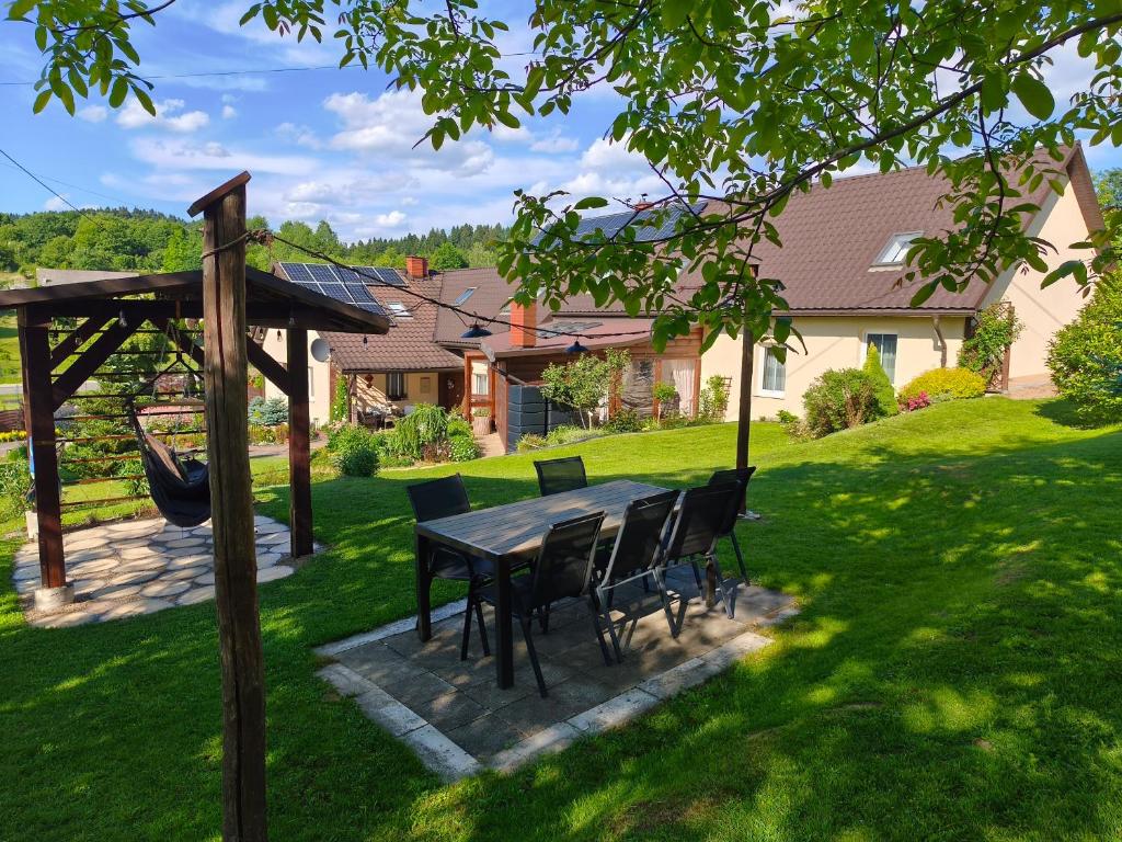 a patio with a table and chairs in a yard at Dom Kowala in Jankowce