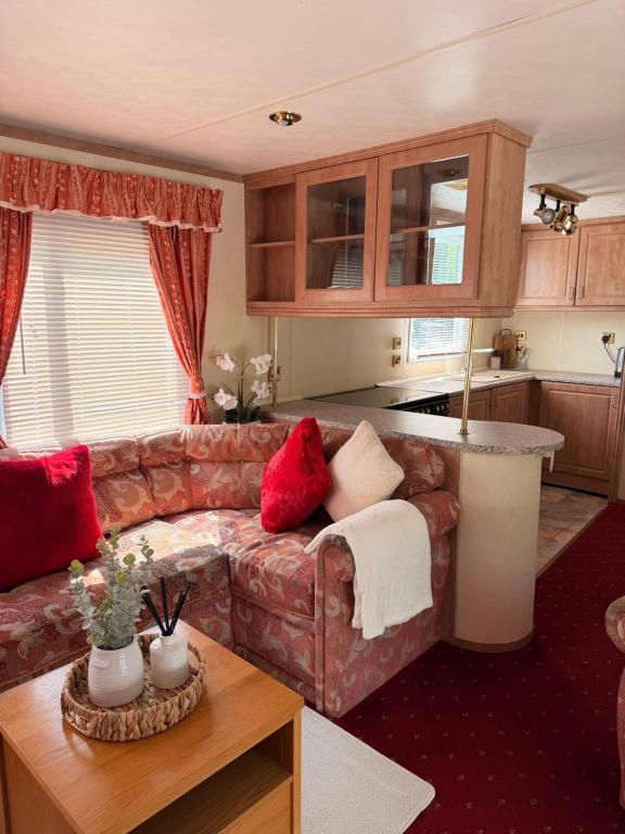 a living room with a couch and a table at Swans Rest - Lakeside Caravan Park in Denver