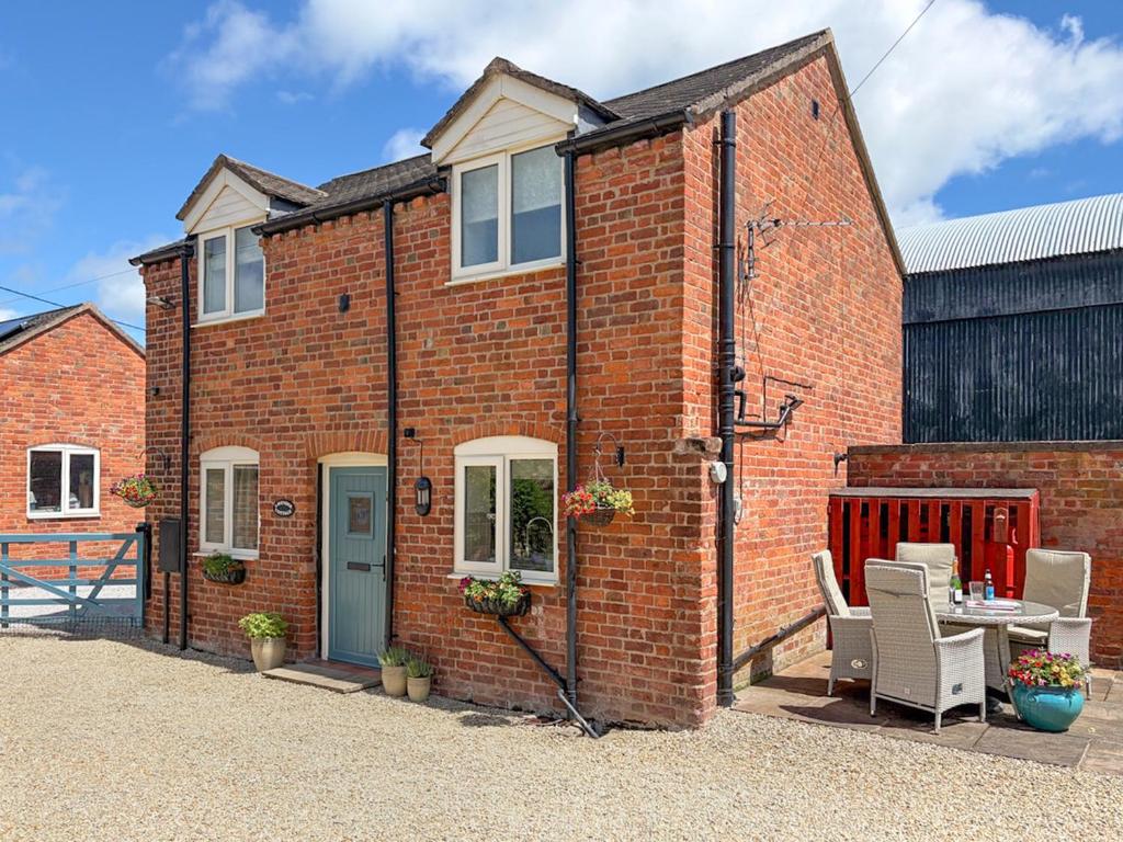 a brick house with a table and chairs outside at Lavender Cottage in Shrewsbury