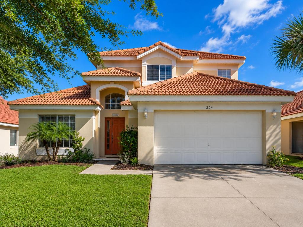 a house with a garage in front of it at 5BR Florida villa with private pool in Davenport