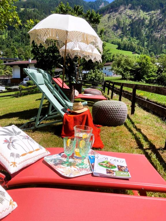 a red table with an umbrella and a drink on it at Mountainspirit in Mayrhofen