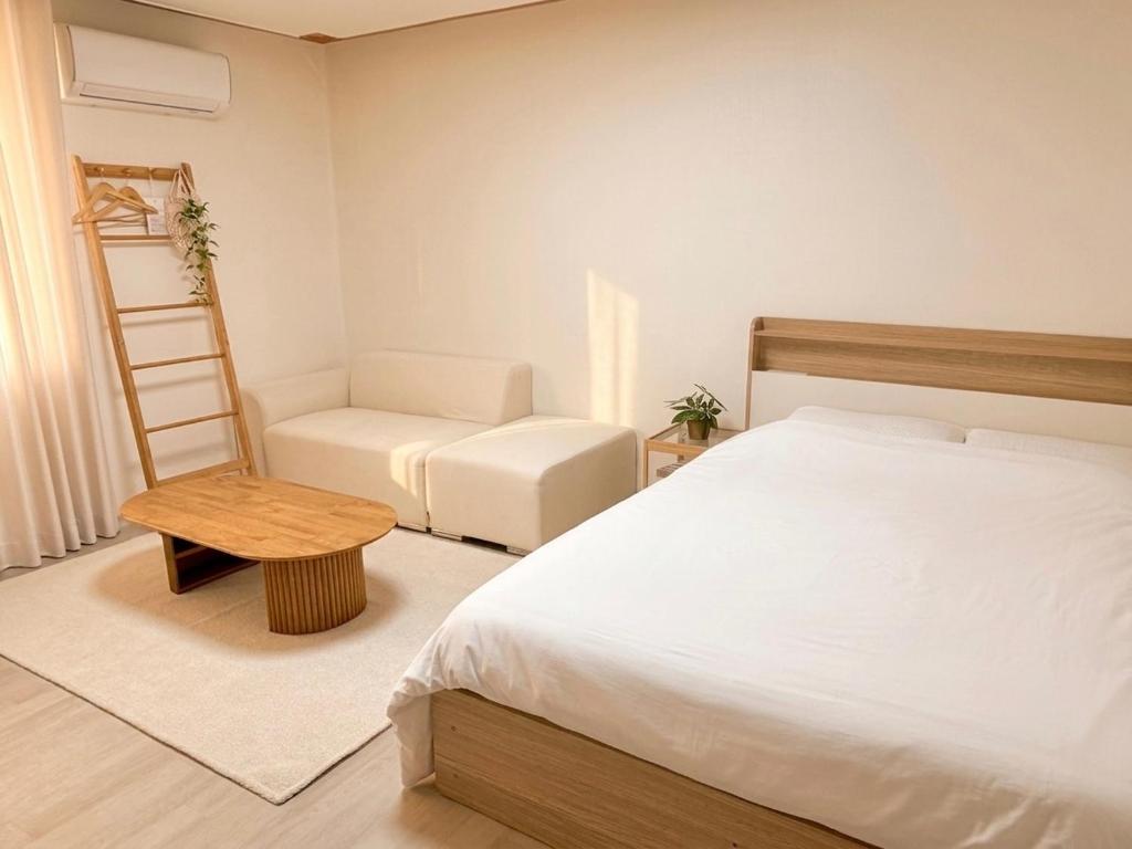 a bedroom with a bed and a chair and a ladder at Stay Joy in Suwon