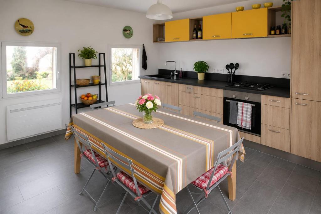 a kitchen with a table with a vase of flowers on it at Seaside house with cliff views in Piriac-sur-Mer