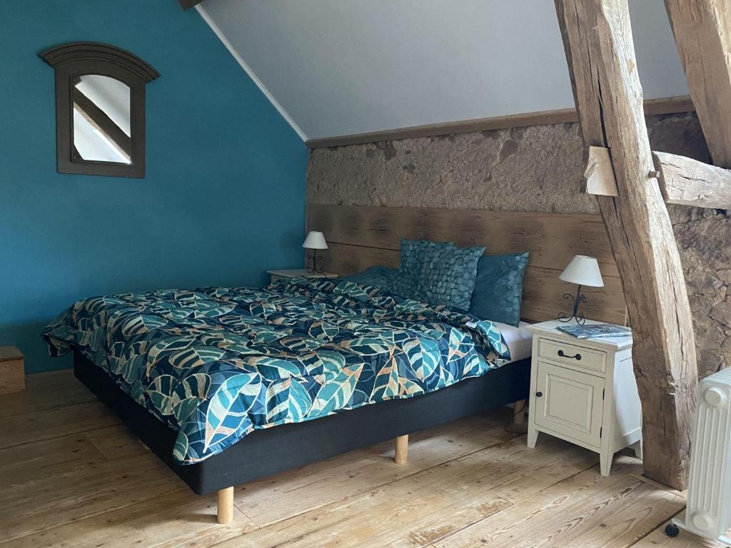 a bedroom with a bed and a blue wall at B&B Les Fruits du Passau in Saint-Désiré