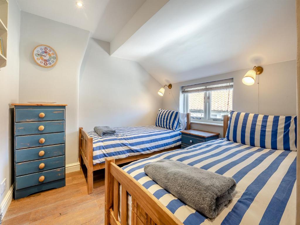 a bedroom with two beds and a blue dresser at 4 Smiddy Hill in Pickering