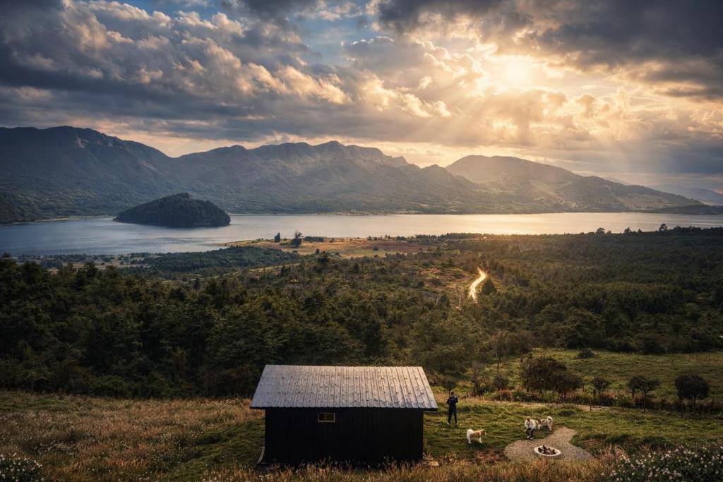 a barn in a field with a view of a lake at Casa Jaguar Neusa in Tausa Viejo