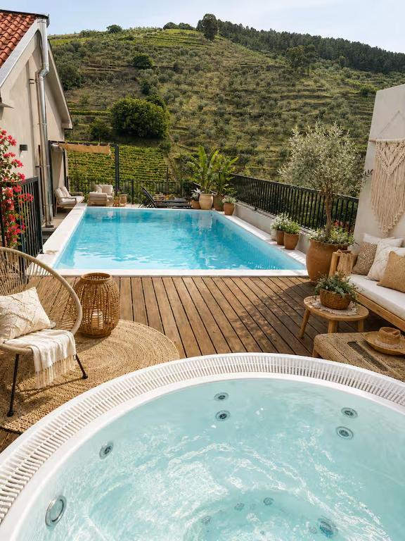 a large swimming pool sitting on a wooden deck at Valadouro Cottage Douro Vallée with a Pool in Espinhosa