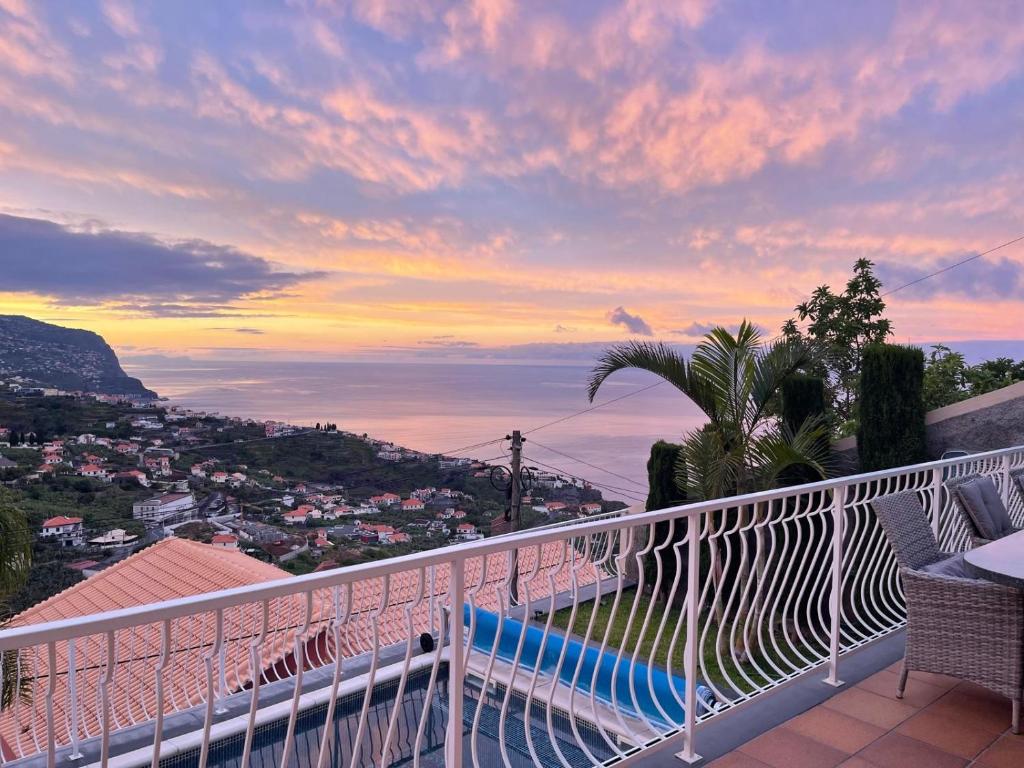 a balcony with a view of the ocean at sunset at Casa Del Mar in Ponta do Sol