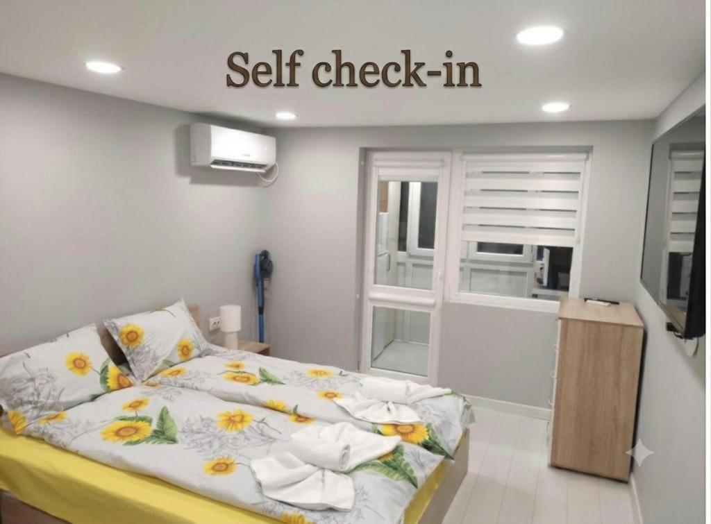 a bedroom with a bed with a self check in sign at MiniMo in Ruse